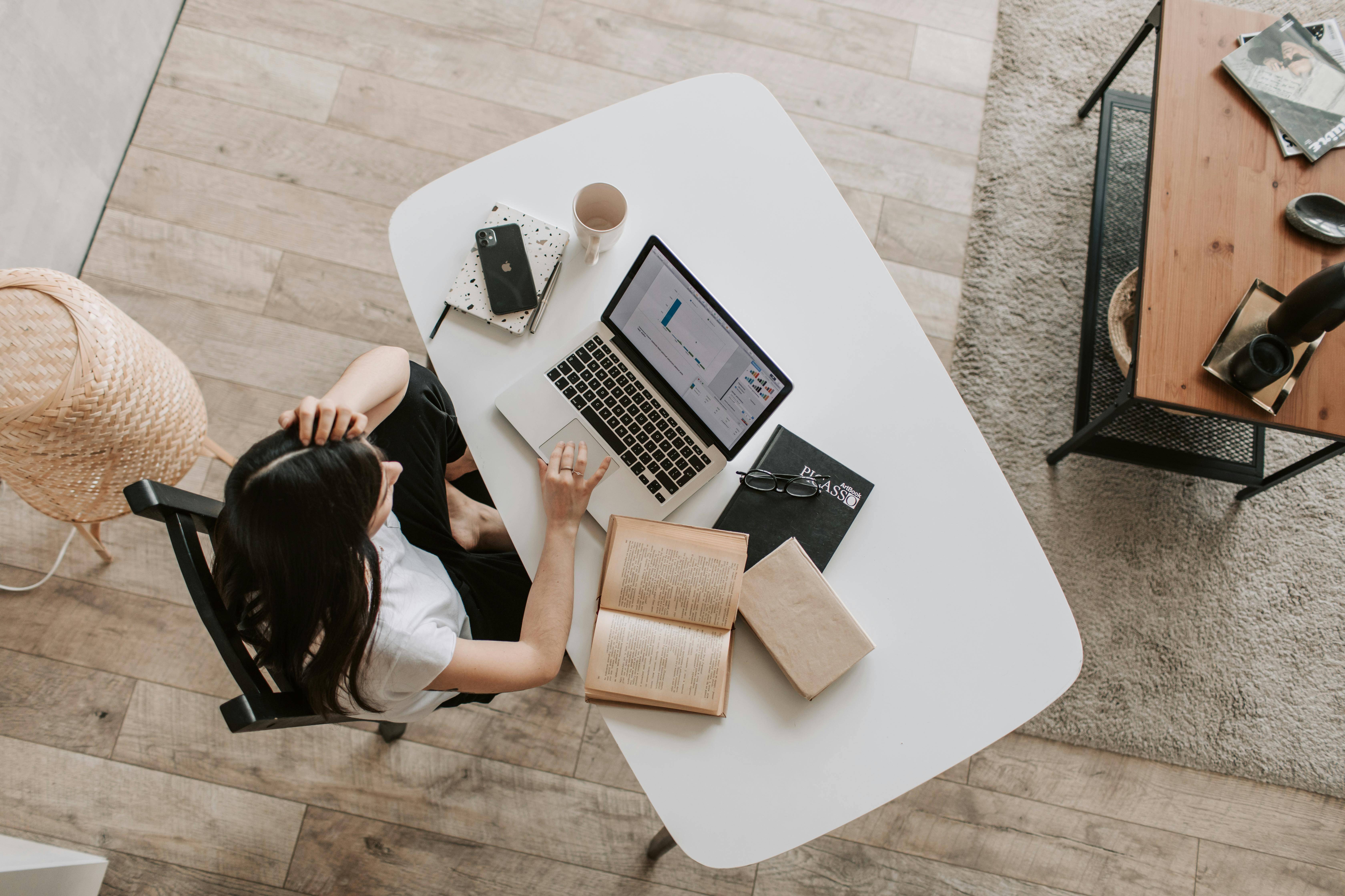 Female preparing online event on a notebook at home. table top view. 